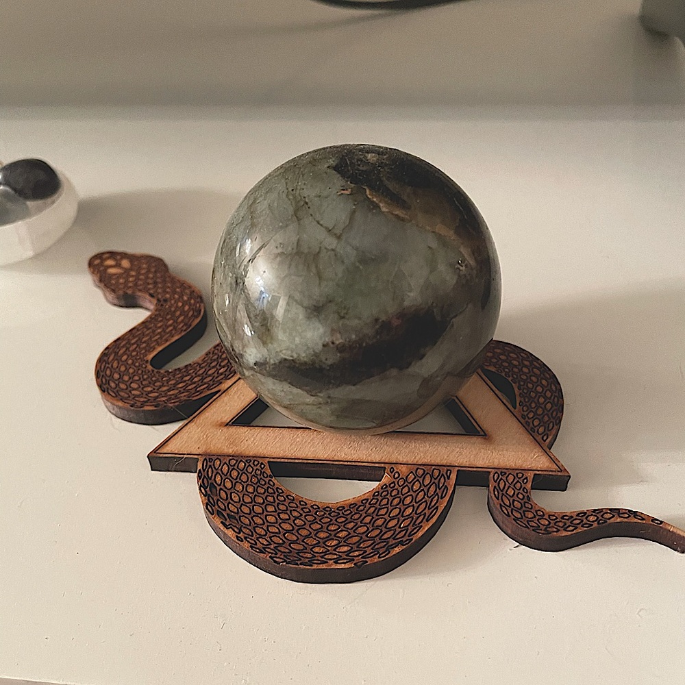 Beautiful labradorite sphere on a triangular snake display stand